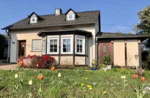 Haus Aussen Blick auf Haus Heinrich mit Tulpen im Vordergrund