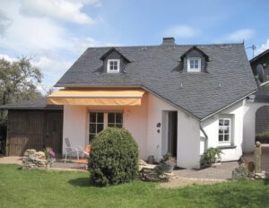 Terrasse von Haus Heinrich, Sitzecke mit Markise und Spielwiese